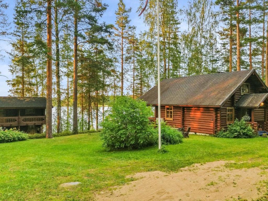 a log cabin in the middle of a field with trees at Holiday Home Palkinniemi by Interhome in Putikko
