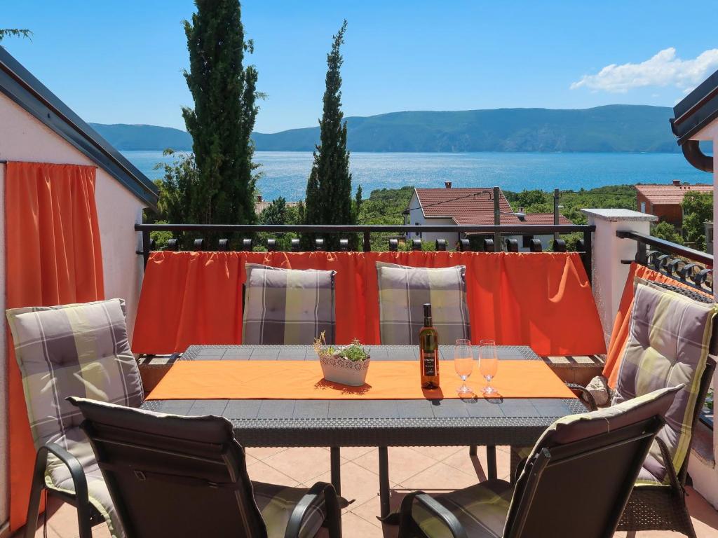 a table on a balcony with a view of the water at Apartment Dilly - KRK117 by Interhome in Pinezici