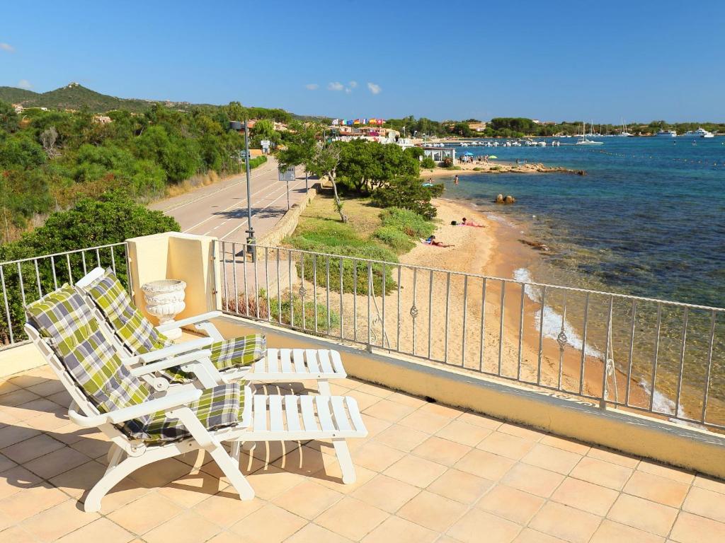 Duas cadeiras sentadas numa varanda com vista para uma praia em Apartment Paola by Interhome em Cannigione