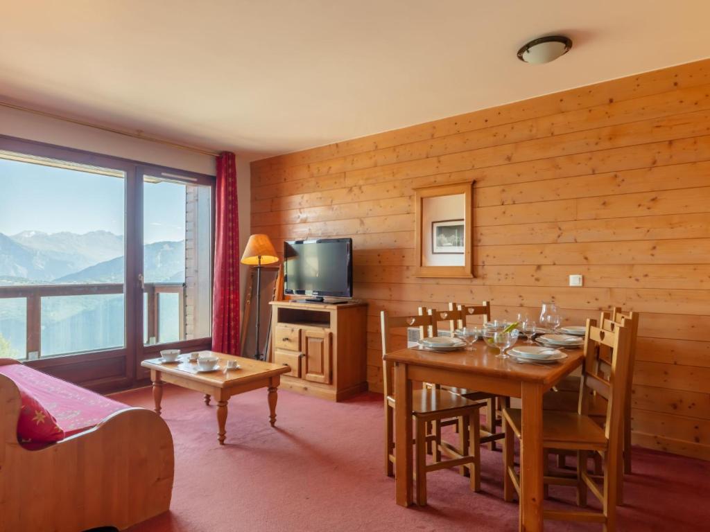 une salle à manger avec une table, des chaises et une télévision dans l'établissement Apartment Les Terrasses du Corbier by Interhome, au Corbier