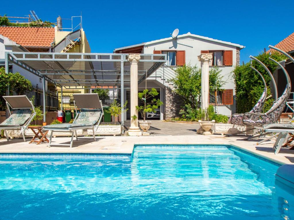 - une piscine avec des chaises et une maison dans l'établissement Apartment Johanna by Interhome, à Tribunj