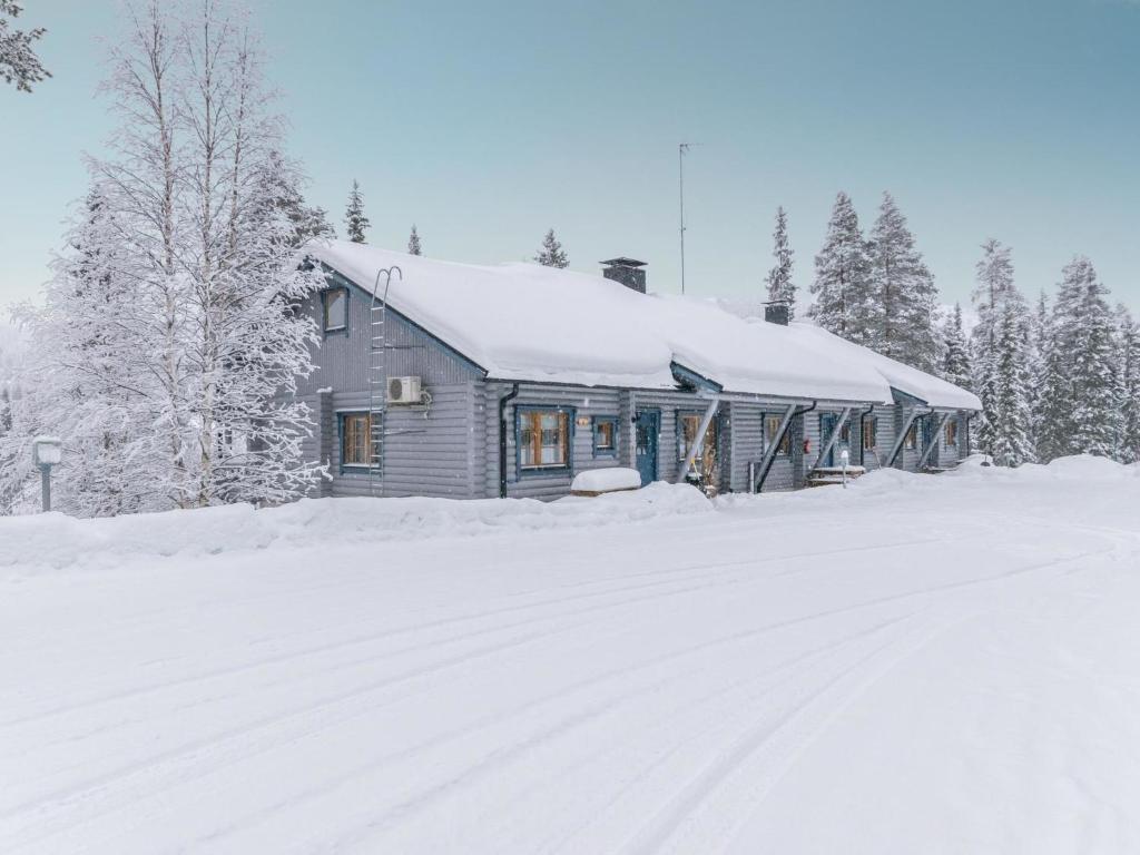 a house covered in snow next to a snow covered road at Holiday Home Karhunpesä a by Interhome in Kotila