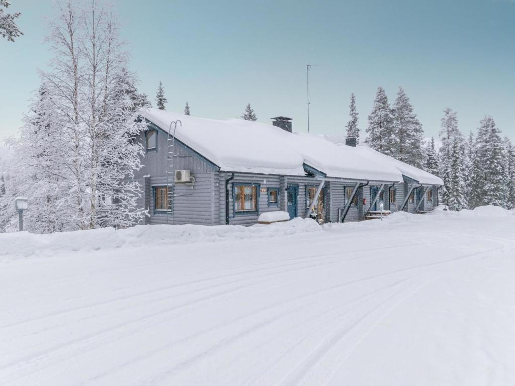 ein schneebedecktes Haus neben einer schneebedeckten Straße in der Unterkunft Holiday Home Karhunpesä a by Interhome in Kotila