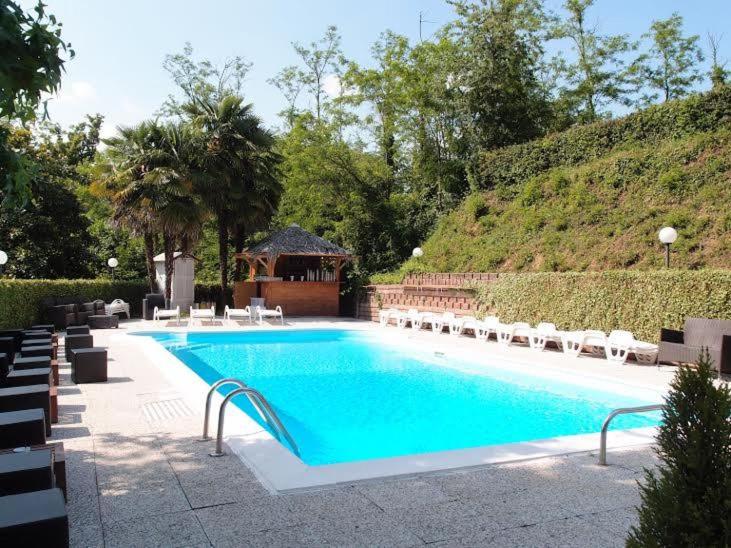 a swimming pool with chairs and a gazebo at Hotel Fossati in Triuggio