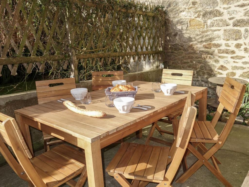 - une table en bois avec des chaises et un bol de nourriture dans l'établissement Apartment Ker Louis-1 by Interhome, à Dinard