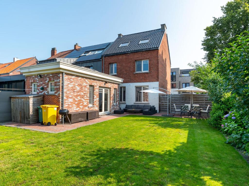 a backyard with a brick house with a lawn at Villa Jasmine by Interhome in Mol