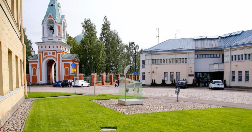 un edificio con una torre de reloj frente a un campo de césped en THE Hotel Finland en Hamina