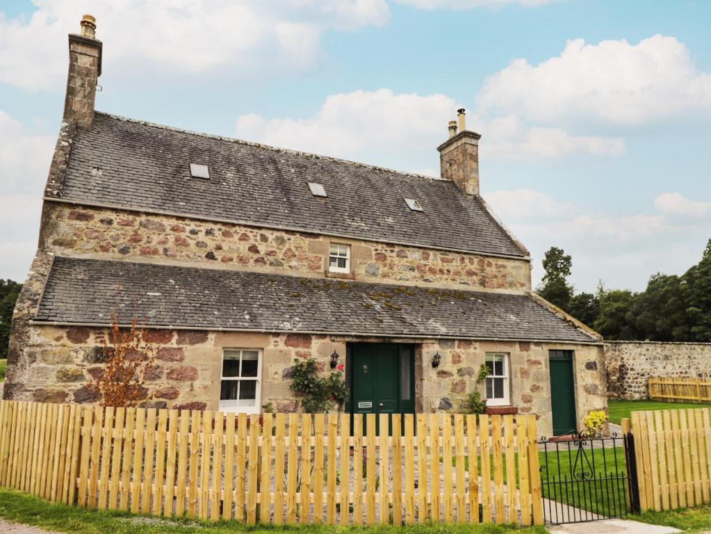 an old stone house with a wooden fence at Garden House - Brodie Castle in Forres