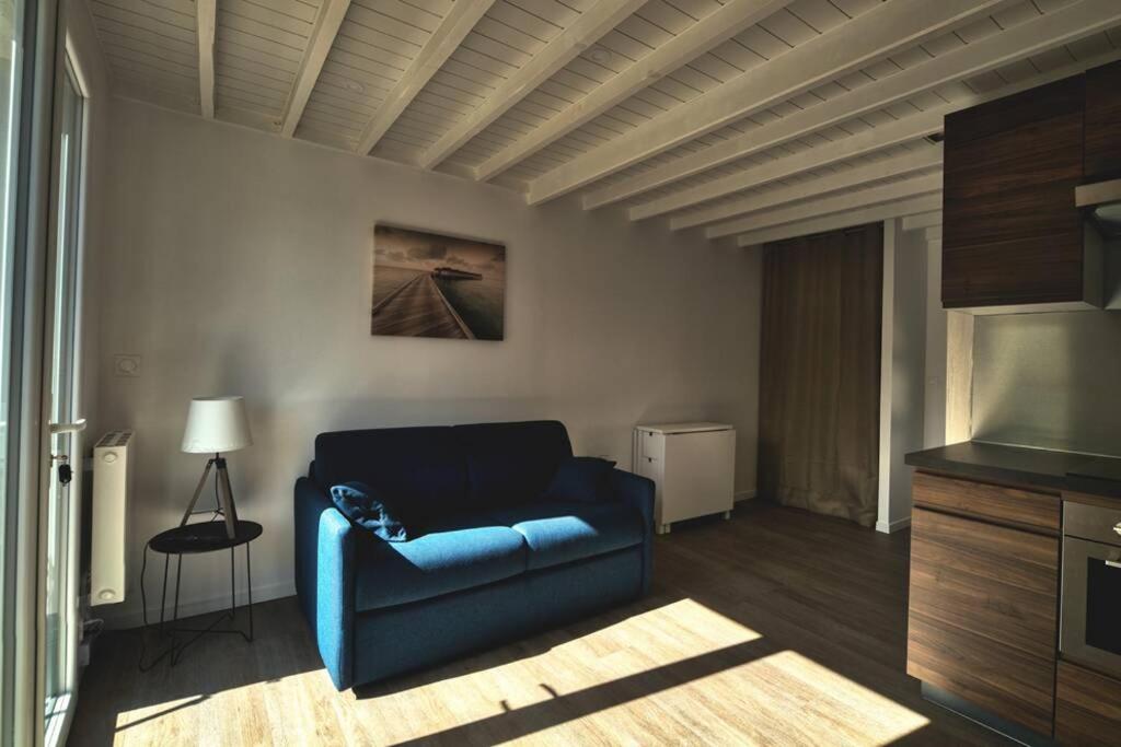 uma sala de estar com um sofá azul e uma televisão em Maison de vacances dans résidence avec piscine em Sarzeau