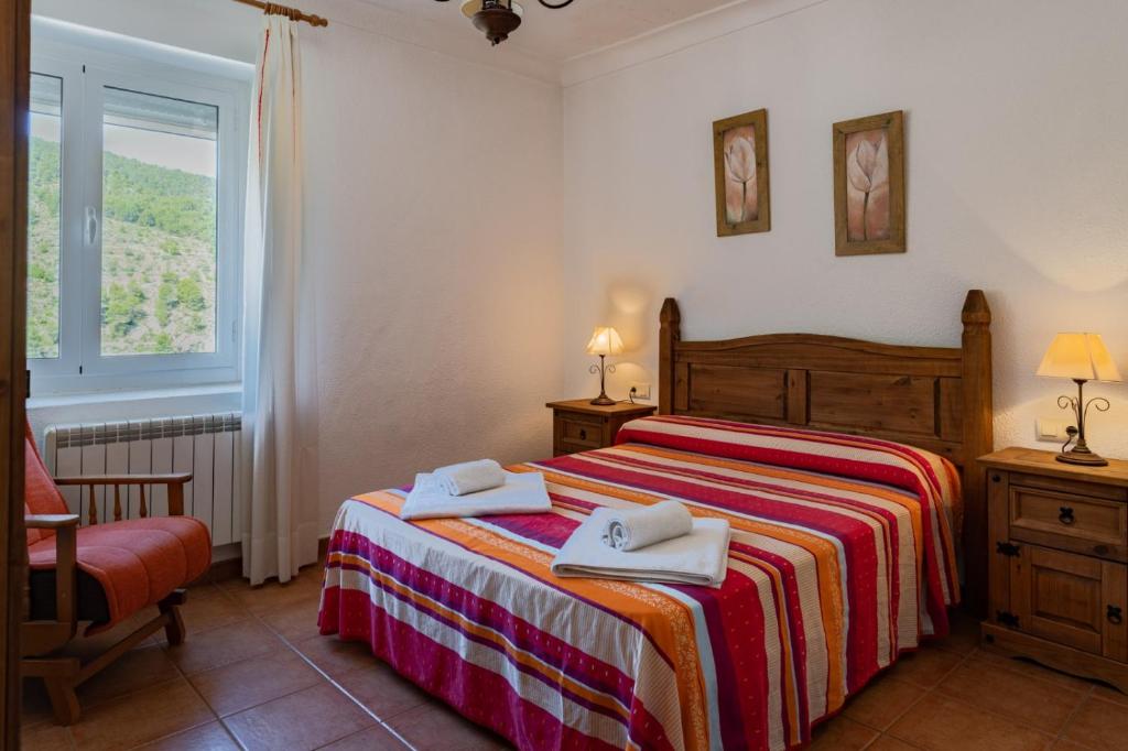 a bedroom with a bed with two towels on it at Casas Rurales Balcón de las Mayas in Ayna