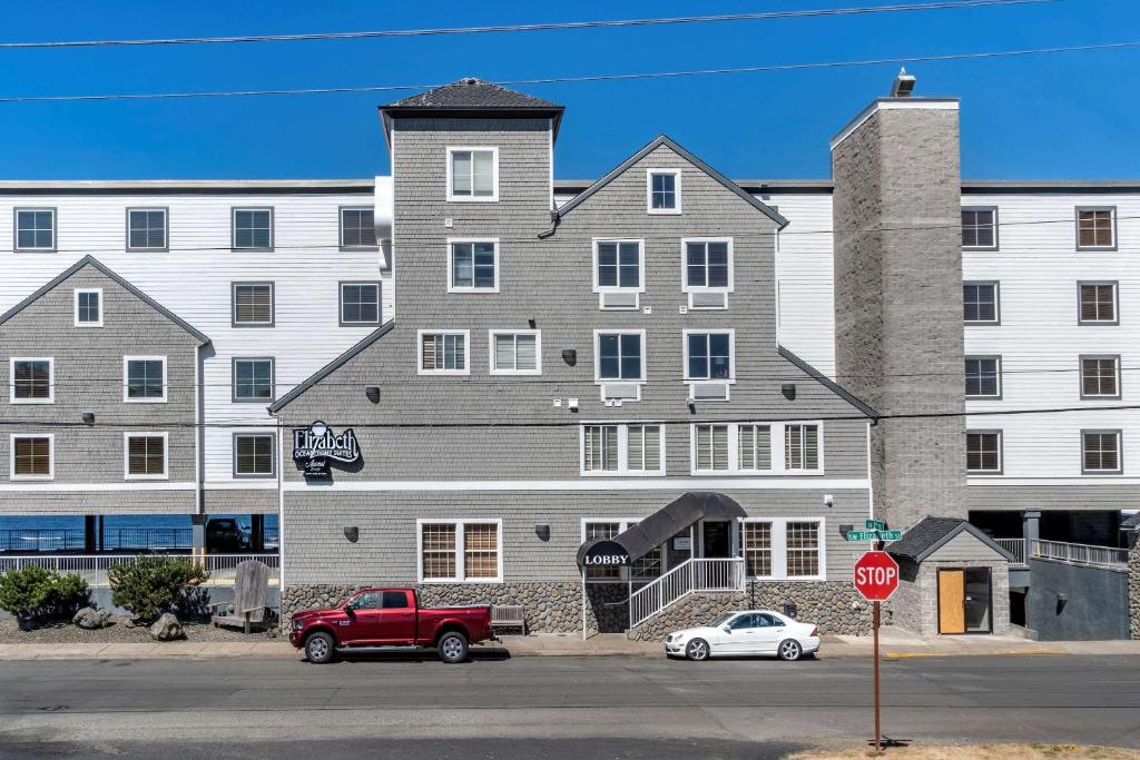 un camion rosso parcheggiato di fronte a un grande edificio di Elizabeth Oceanfront Suites, Ascend Hotel Collection a Newport