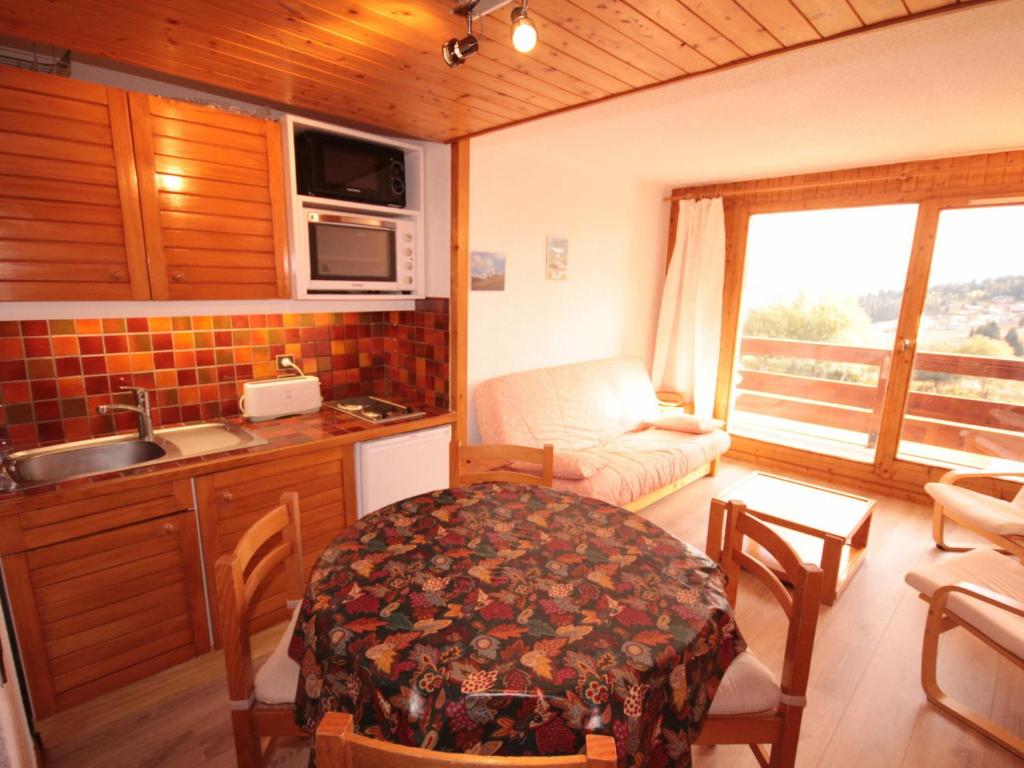 a kitchen and living room with a table and a couch at Studio Les Saisies, 1 pièce, 4 personnes - FR-1-293-230 in Les Saisies