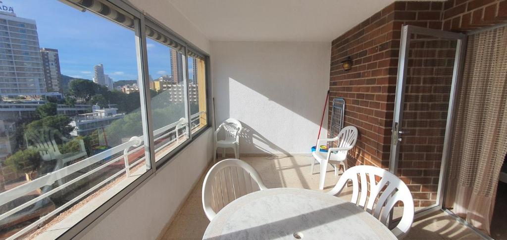 a balcony with a table and chairs and a window at COBLANCA 20 - Fincas Arena in Benidorm