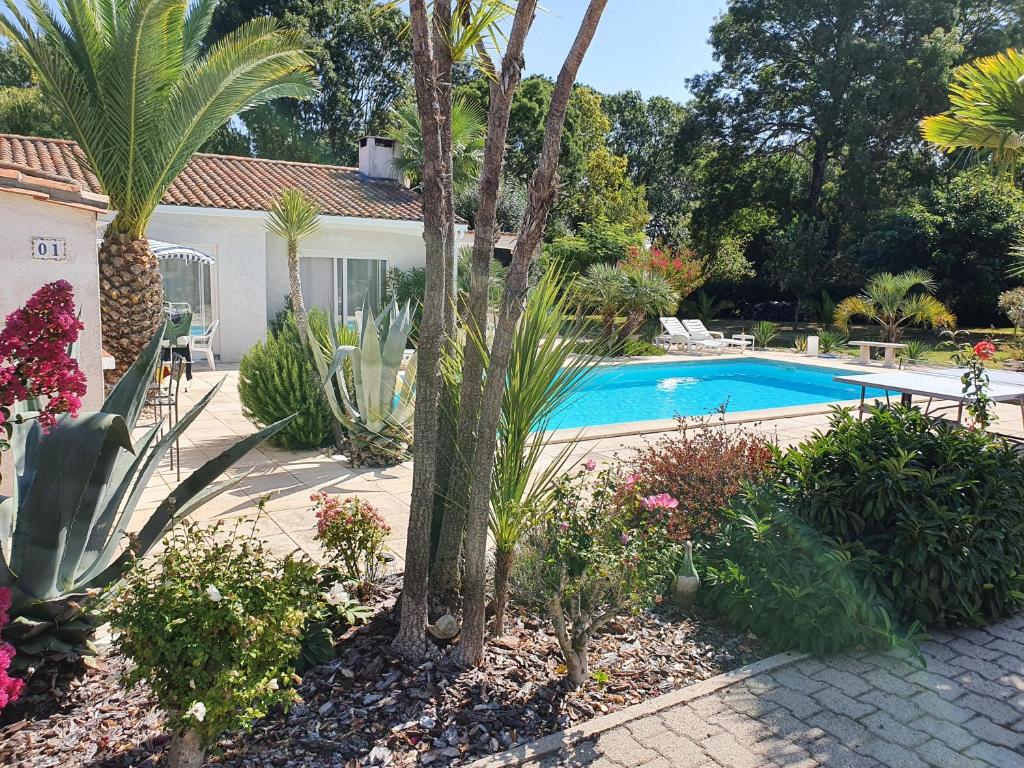 un jardin avec une piscine et des plantes dans l'établissement VILLA MEDOC OCEAN 2, à Talais