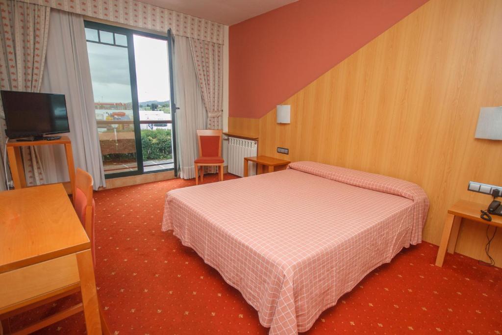 a hotel room with a bed and a television at Hotel Mirador de Gornazo in Gormazo