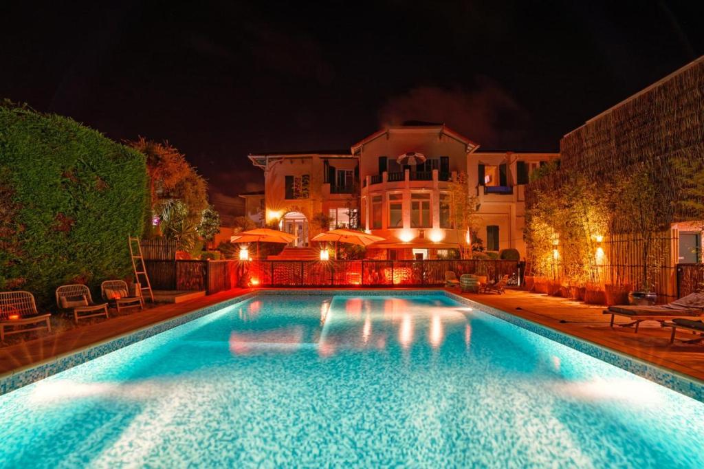 a swimming pool in front of a house at night at La Garoupe-Gardiole in Antibes
