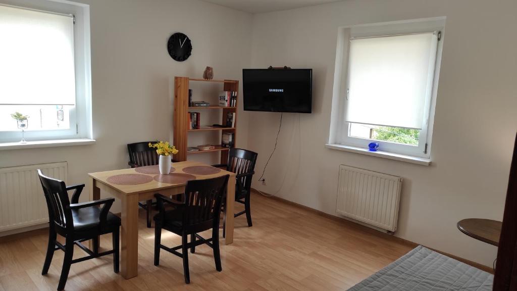 a dining room with a table and chairs and a tv at Apartament przy Wrocławskim Stadionie in Wrocław