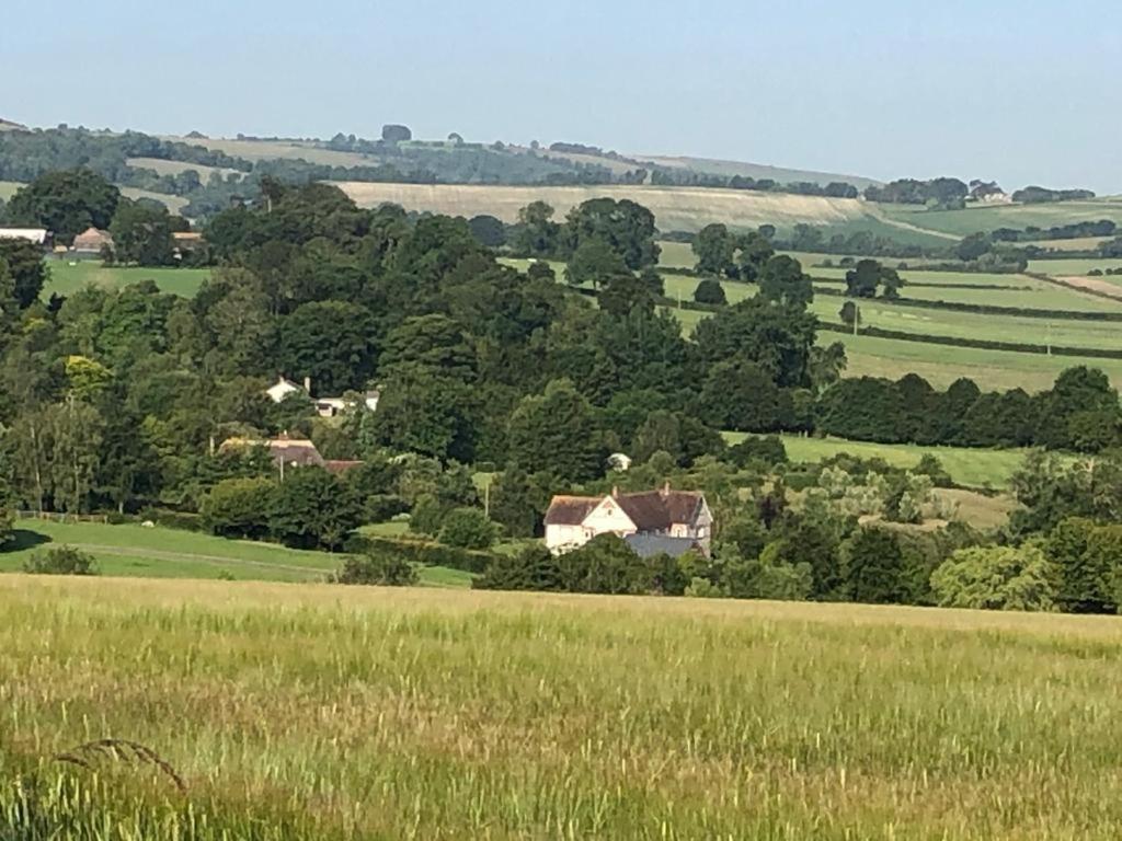 a house in the middle of a green field at Impstone House B & B in Bower Chalke