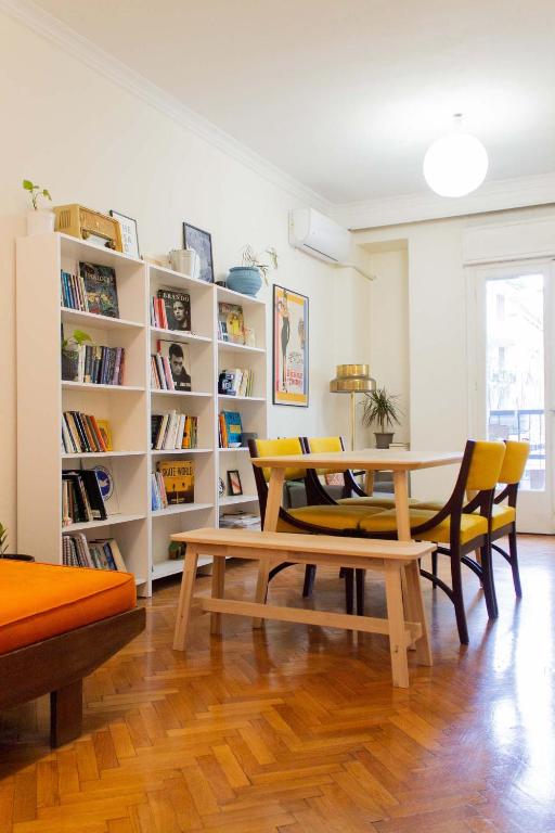 salon ze stołem, krzesłami i półką na książki w obiekcie Aristotelous Square Apartment w Salonikach