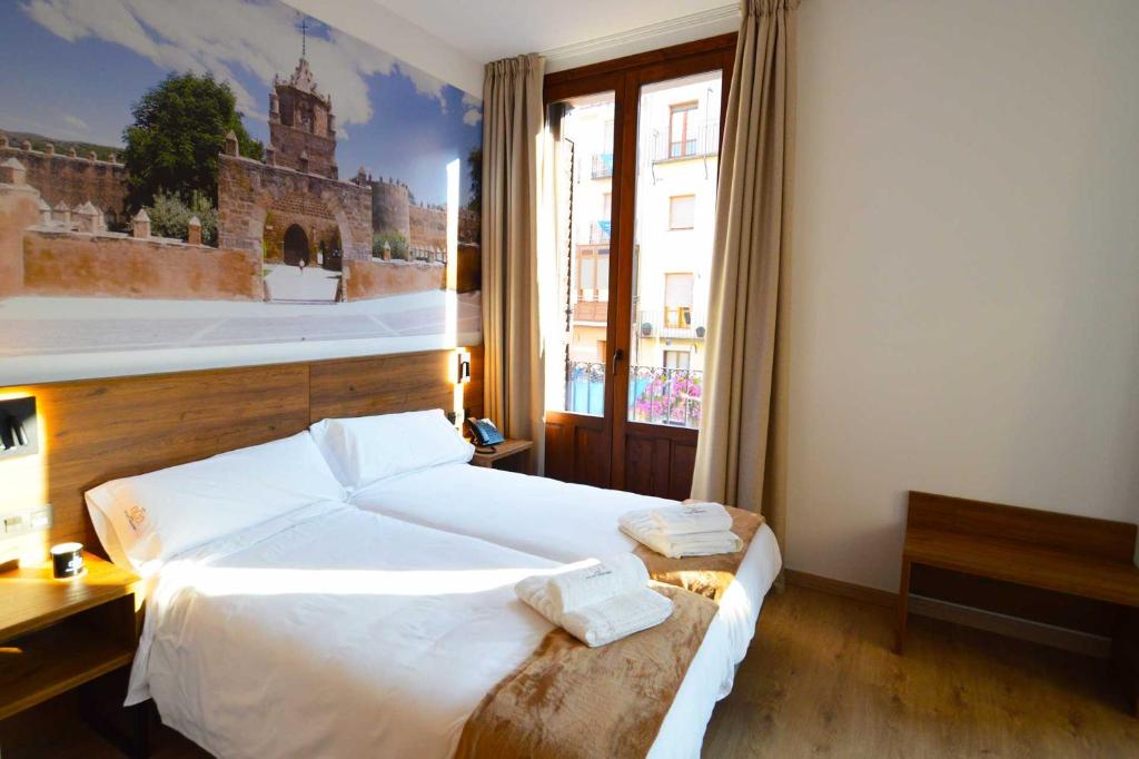 a bedroom with a large bed and a large window at Encanto Tarazona in Tarazona de Aragón