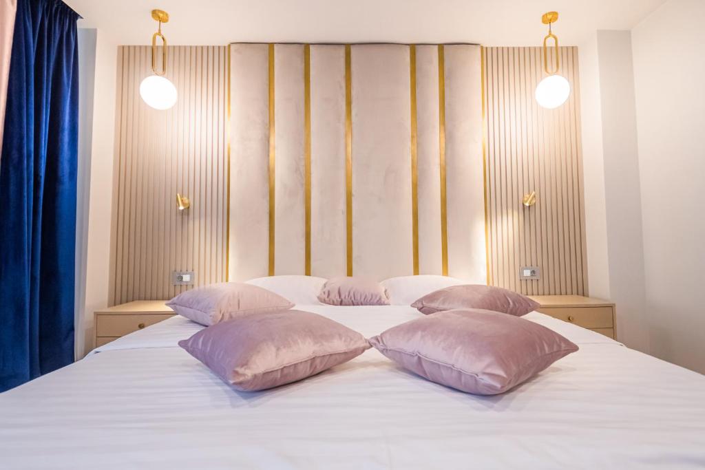 łóżko z 3 poduszkami na górze w obiekcie Pensiunea Iristar w mieście Fălticeni