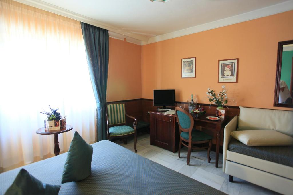 ルチェーラにあるBalconata 2.0 Banqueting & Accommodationsのベッド、デスク、コンピュータが備わるホテルルームです。