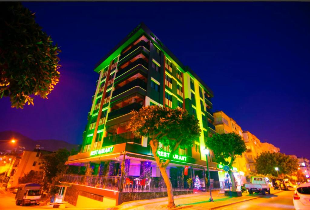 a green building with a tree in front of it at Avlion Boutique Hotel in Alanya