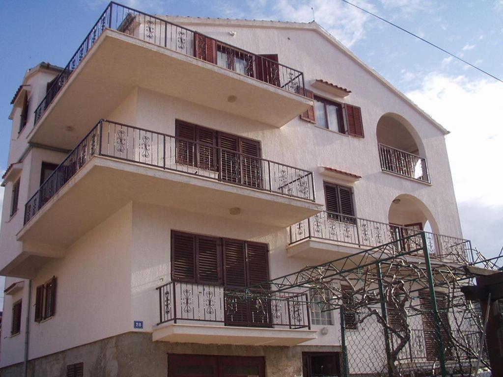 a tall white building with balconies on it at Apartments Ivanka in Zadar