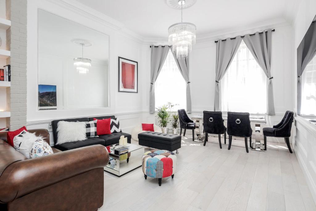 een woonkamer met banken en stoelen en een tafel bij Oxford Street 2 Bed Apartment in Londen
