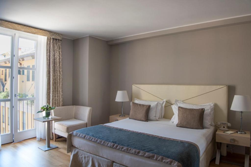 a bedroom with a bed and a chair and a window at Grand Hotel Portovenere in Portovenere