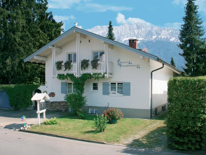 a white house with plants on the front of it at Vergissmeinnicht Ferienwohnungen in Oberaudorf