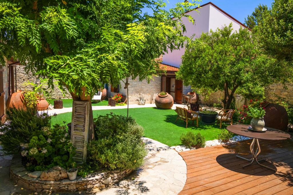 een tuin met een houten terras met een tafel en bomen bij Listed Villa in Laneia in Lania