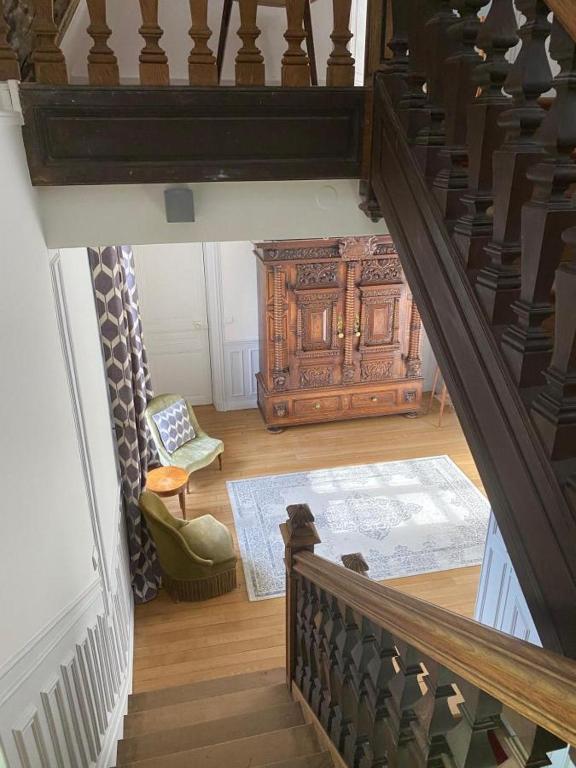 Un escalier mène à un salon avec une armoire en bois. dans l&#39;établissement Propriété Les Ruisseaux, à Seine-Port