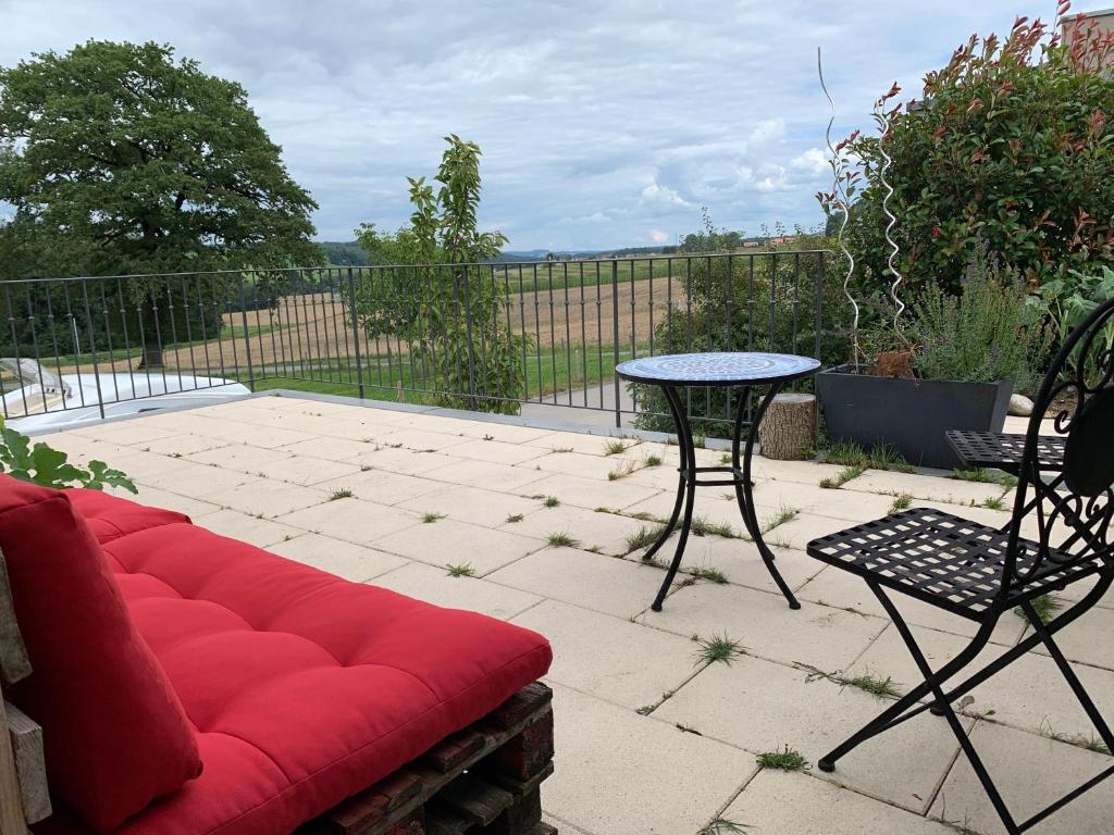 a red couch and a table on a patio at C&C motorhome/RV/caravan/van park in La Sonnaz