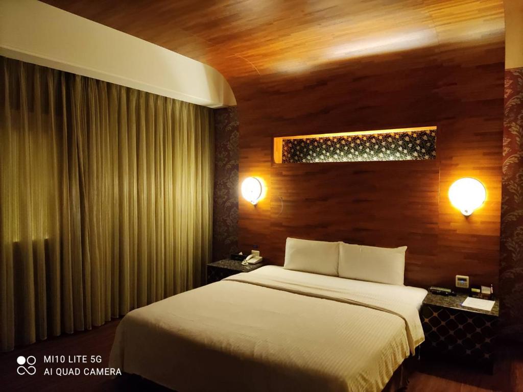 大溪區的住宿－碧雲天汽車旅館-大溪館，一间卧室设有一张床和木墙