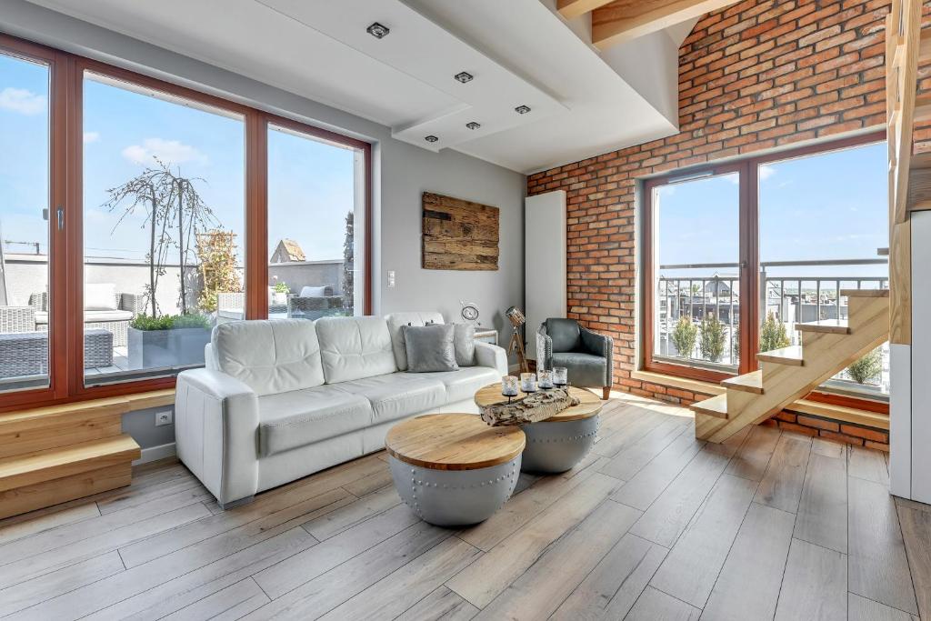 a living room with a white couch and large windows at Dom & House - Apartments Waterlane Island in Gdańsk