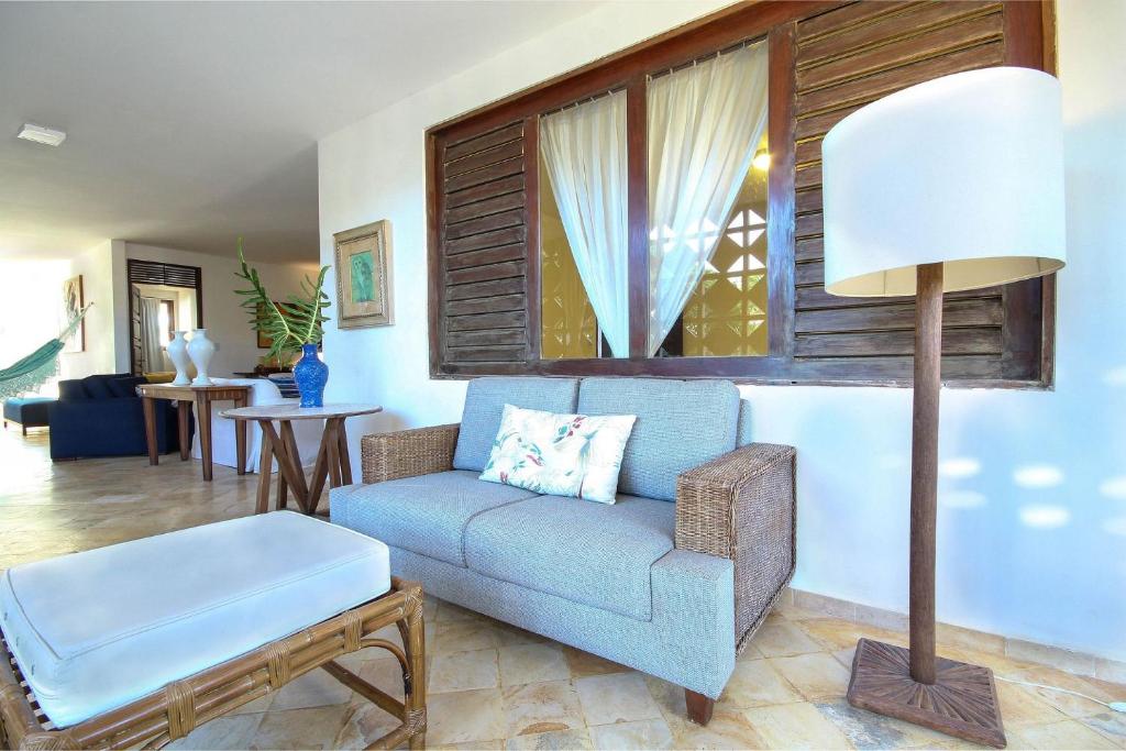 a living room with a blue couch and a table at Casa pé na areia na Praia de Genipabu by Carpediem in Extremóz
