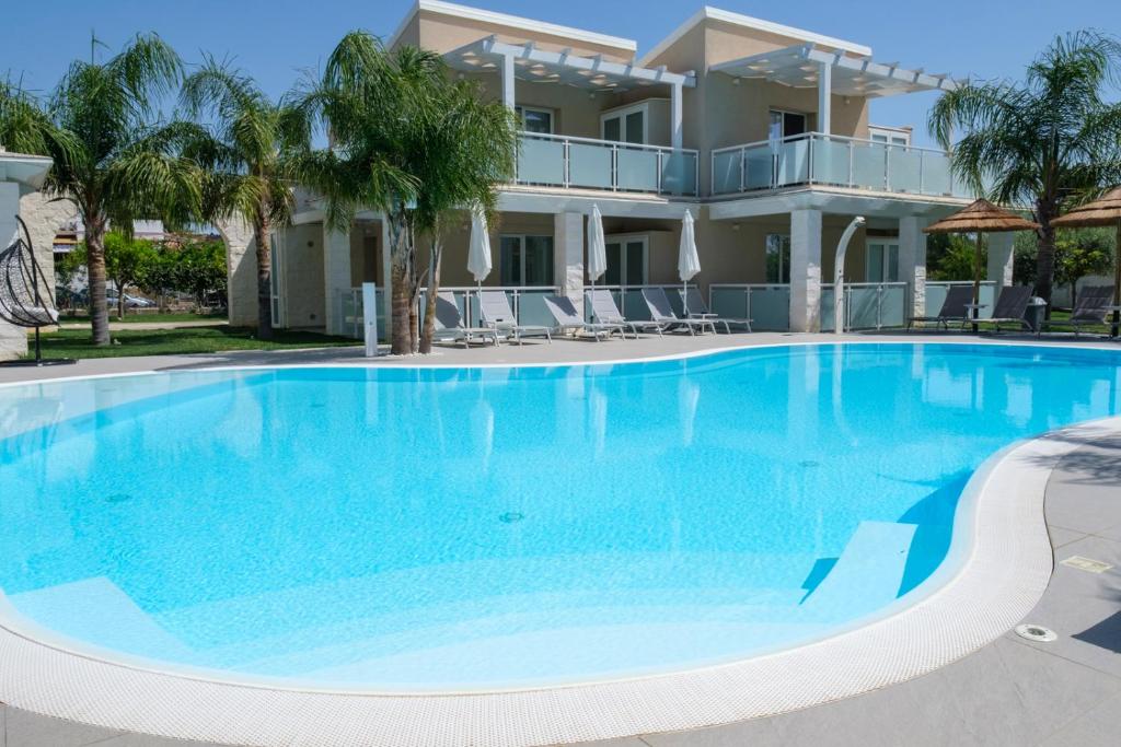 a large blue swimming pool in front of a house at Pietra Bianca Marzamemi in Marzamemi