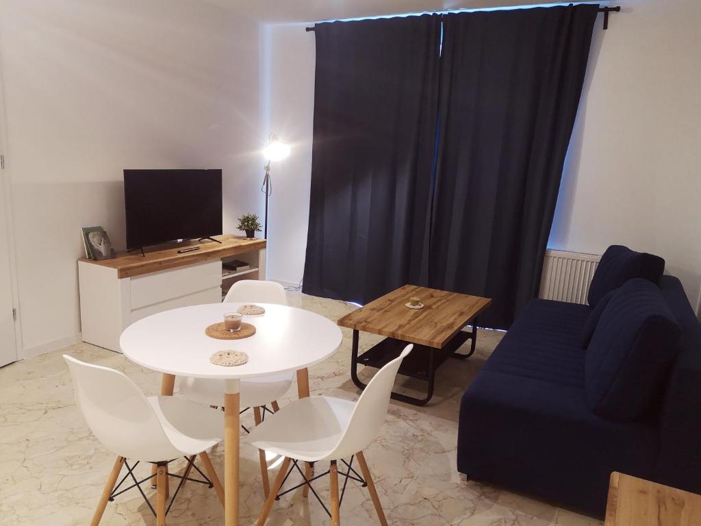Apartament Źródełko في بوخنية: غرفة معيشة مع طاولة وأريكة زرقاء