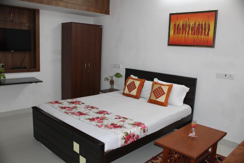 Schlafzimmer mit einem Bett, einem Tisch und einem TV in der Unterkunft Friendlystay - An Home Stay And Elite in Chennai