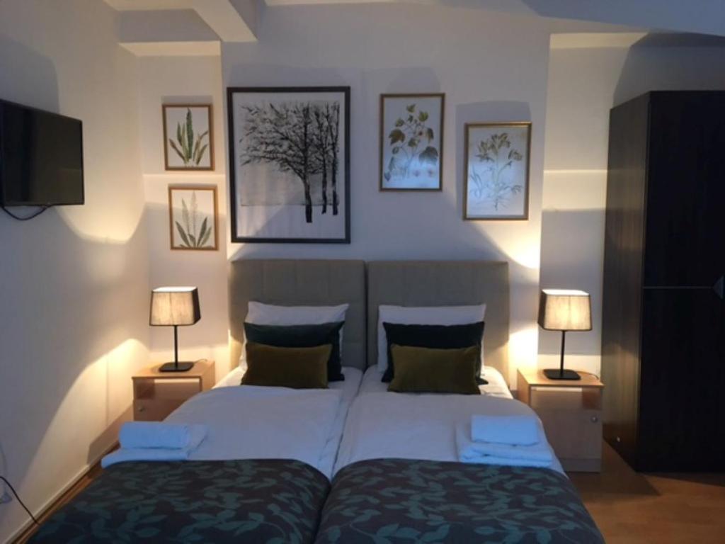 1 dormitorio con 2 camas y 2 lámparas en Hotel Corner en Sarajevo