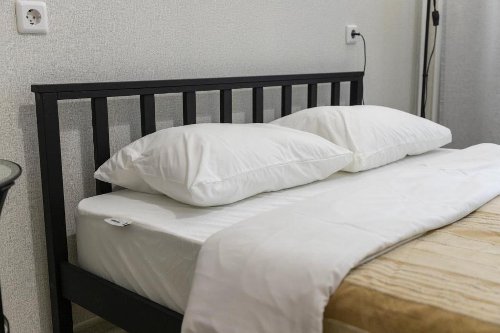 チェリャビンスクにあるАпартаменты Урал Колсанова 6のベッド1台(上に白い枕2つ付)