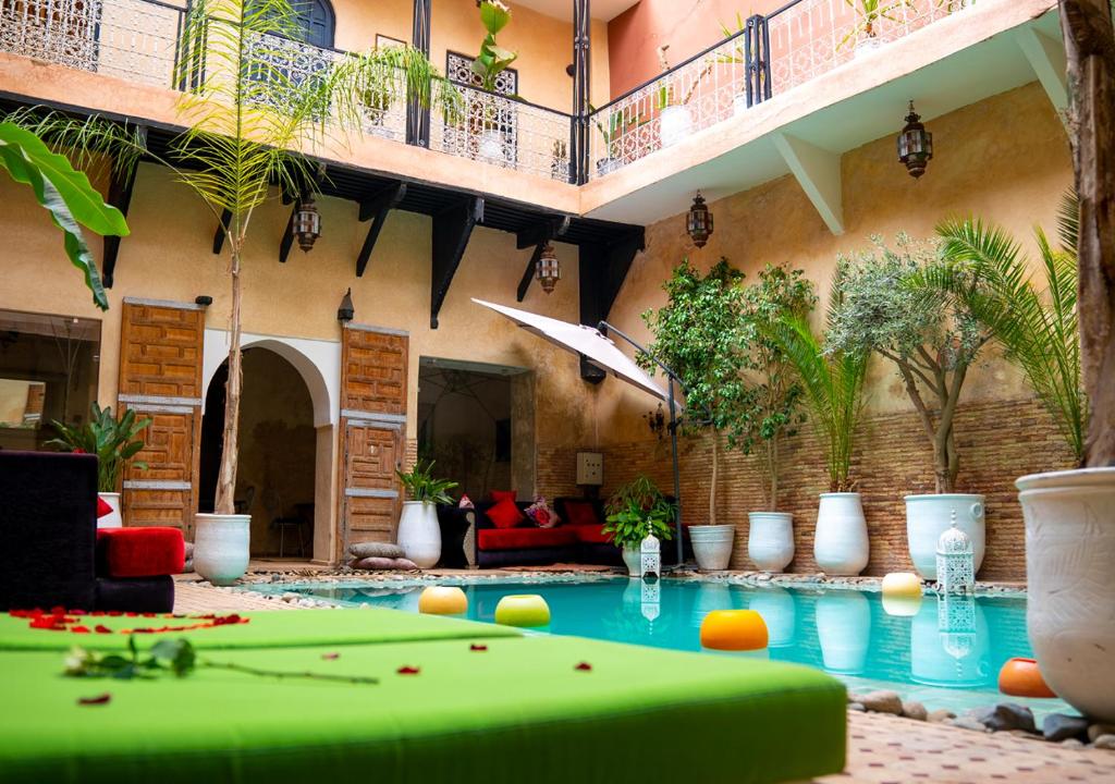 einem Pool in der Mitte eines Gebäudes mit Billardtisch in der Unterkunft Riad Romance in Marrakesch