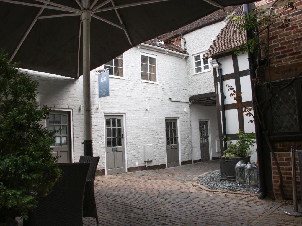 an umbrella in front of a white building at Hazel Cottage in Bridgnorth