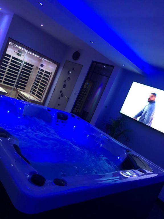 una vasca blu in una camera con TV di Spalace a Cuincy