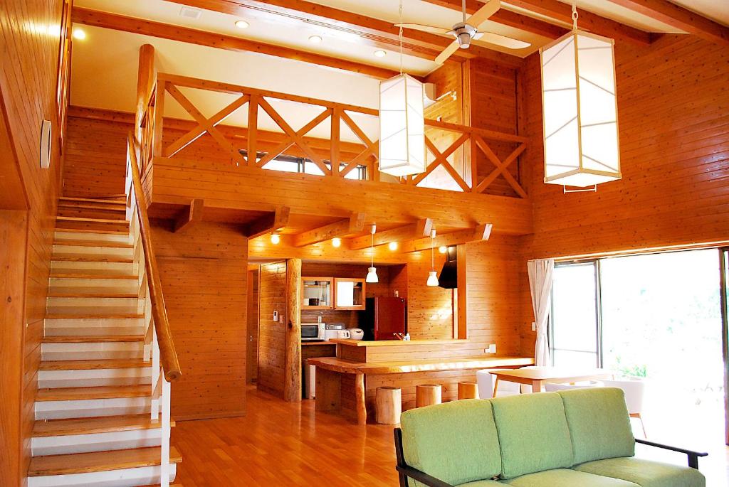 ein Wohnzimmer mit einer Treppe und einer grünen Couch in der Unterkunft Karin Design Cottage in Onna