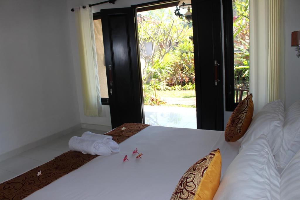a bedroom with a bed with a towel on it at Magus Homestay in Pemuteran