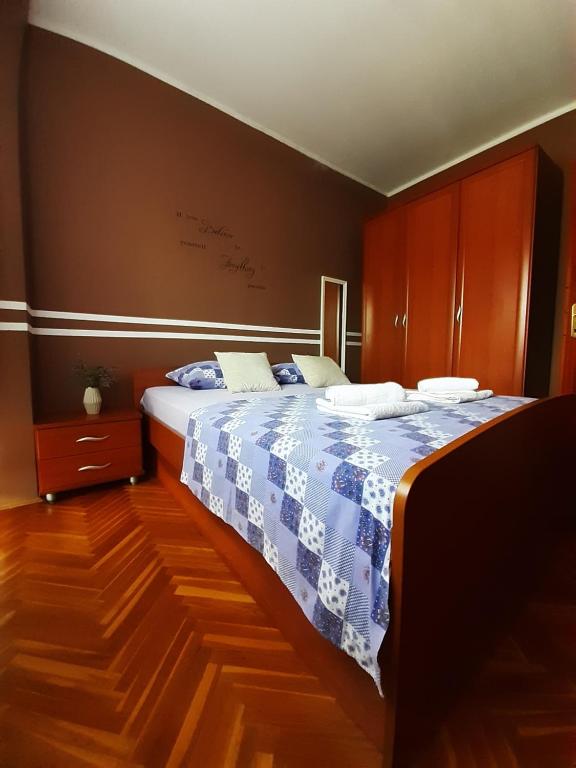 um quarto com uma cama com um cobertor azul e branco em Apartment Gloria em Zadar