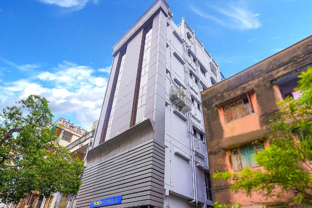 un grand bâtiment blanc sur le côté d'une rue dans l'établissement FabHotel Eros 211, à Kolkata