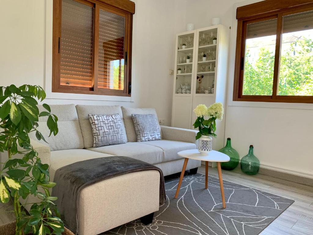 ein Wohnzimmer mit einem Sofa und einem Tisch in der Unterkunft A Casa Vermella con jardín a 10 minutos de Santiago de Compostela in Ortoño